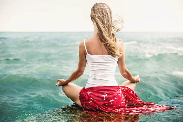 Ung kvinna meditation på stranden — Stockfoto