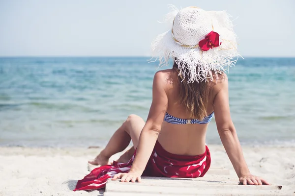 Žena sedí na pláži — Stock fotografie