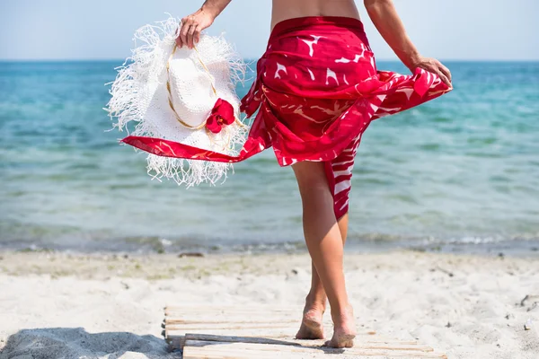 Vrouw wandelingen op het strand — Stockfoto