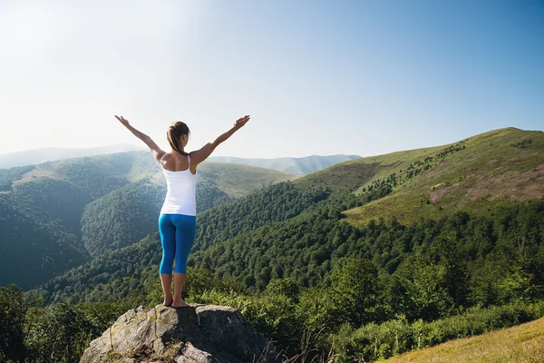 Jonge vrouw mediteren op de bovenkant van berg — Stockfoto
