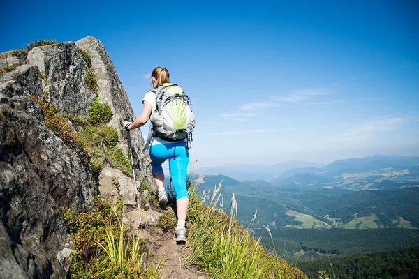 Jovem mulher caminhando nas montanhas — Fotografia de Stock