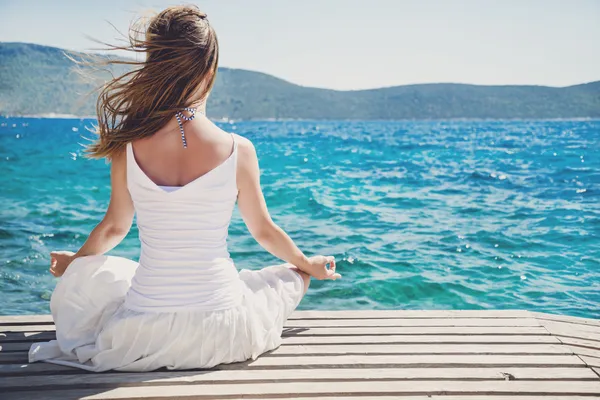 Kvinna mediterar vid havet — Stockfoto