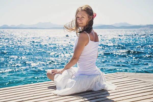 Vrouw zitten op het strand — Stockfoto