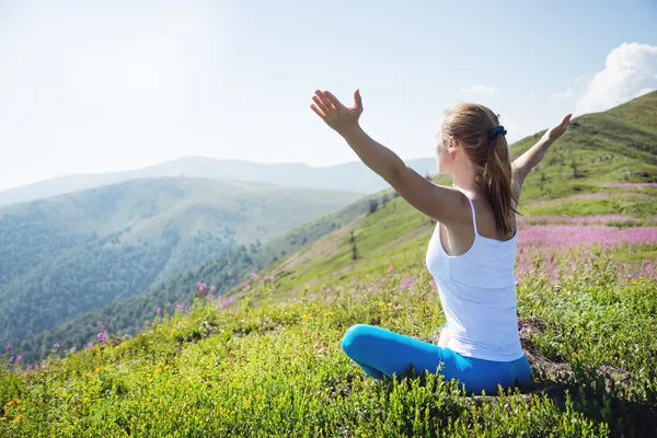 Ung kvinna meditera på toppen av berg — Stockfoto