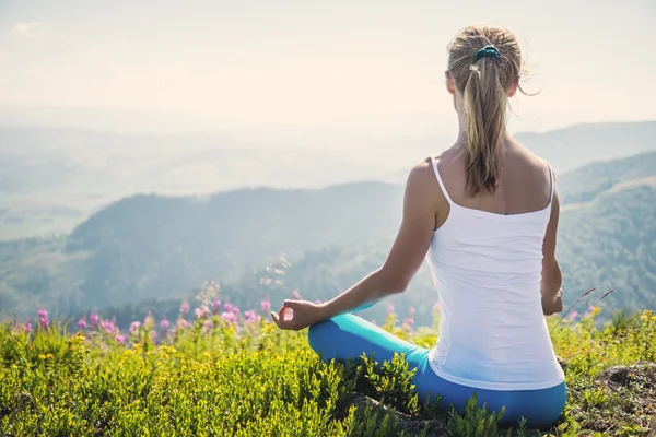 Mujer joven meditar en la cima de la montaña — Foto de Stock