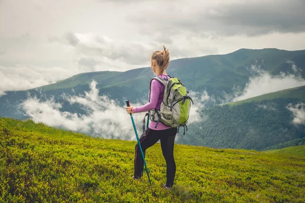 Jovem mulher caminhando nas montanhas — Fotografia de Stock