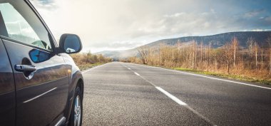 Dağ yolunda seyahat etmek için bir araba. Mavi gökyüzü