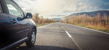 Dağ yolunda seyahat etmek için bir araba. Mavi gökyüzü