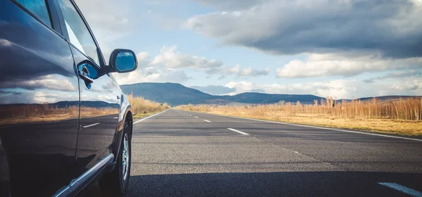 Dağ yolunda seyahat etmek için bir araba. Mavi gökyüzü