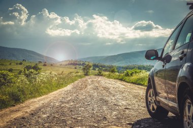 Dağ yolunda seyahat etmek için bir araba. Mavi gökyüzü