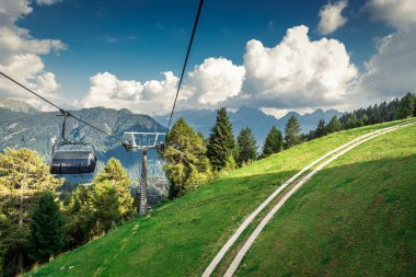 Dağ kayak merkezinde teleferik, yeşil orman. Alpler. İtalya