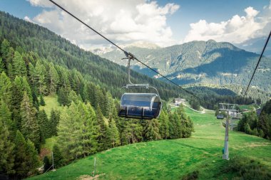 Dağ kayak merkezinde teleferik, yeşil orman. Alpler. İtalya
