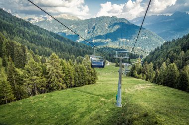 Dağ kayak merkezinde teleferik, yeşil orman. Alpler. İtalya