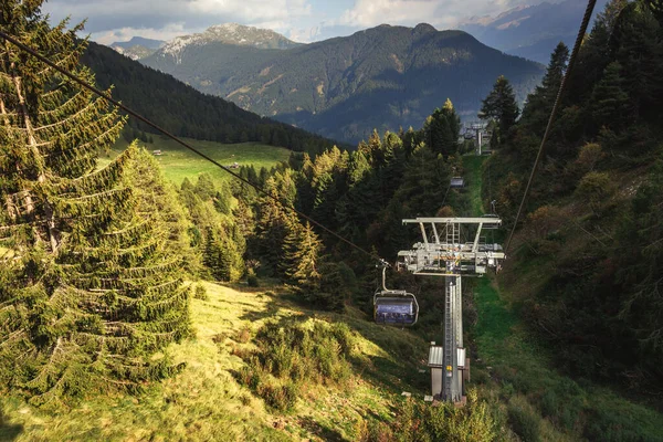 gondola ski lift in mountain ski resort, green forest. Alps. Italy