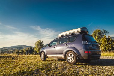Dağ yolunda seyahat etmek için bir araba. Mavi gökyüzü