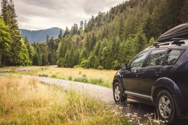 Dağ yolunda seyahat etmek için bir araba. Mavi gökyüzü