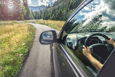 Dağ yolunda seyahat etmek için bir araba. Mavi gökyüzü
