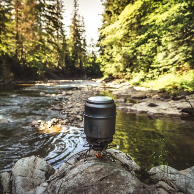 Yürüyüş sırasında kamp benzini kullanarak yemek pişirmek. Nehir. Karpatlar