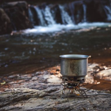 Yürüyüş sırasında kamp benzini kullanarak yemek pişirmek. Nehir. Karpatlar