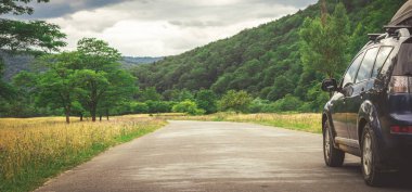 Dağ yolunda seyahat etmek için bir araba. Mavi gökyüzü
