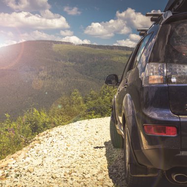 Dağ yolunda seyahat etmek için bir araba. Mavi gökyüzü