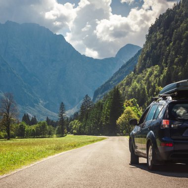 Dağ yolunda seyahat etmek için bir araba. Mavi gökyüzü
