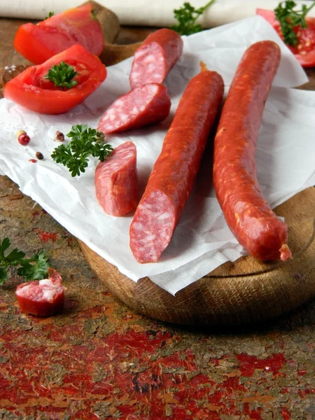 Sausage and vegetables on a wooden board — Stock Photo, Image