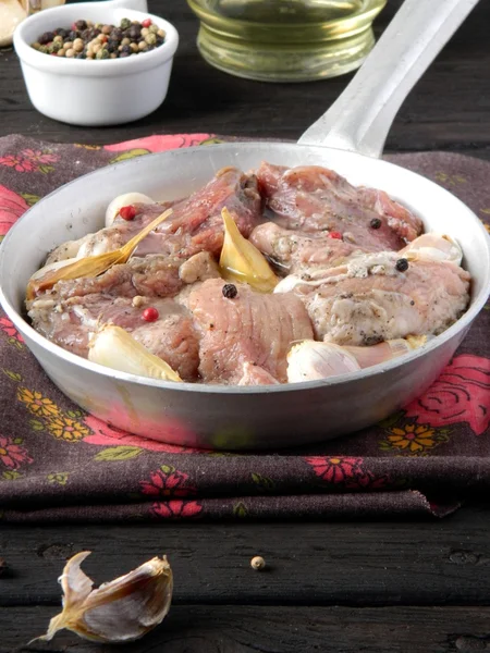 Appetizing meat in a pan on a wooden table — Stock Photo, Image