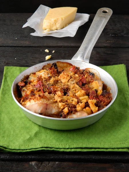 Appetizing dish in the pan on a wooden table — Stock Photo, Image