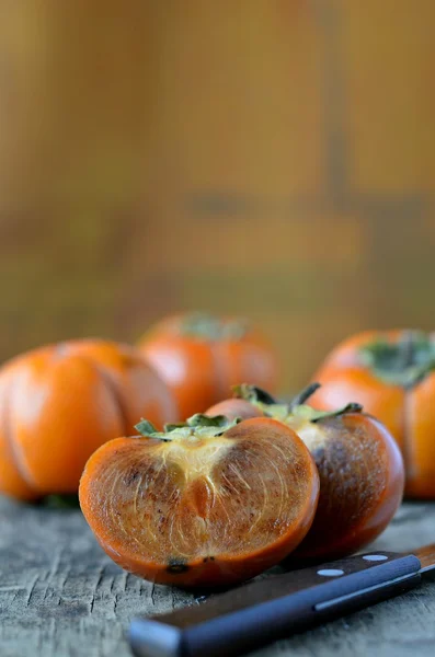 Persimmon on wooden table — Stock Photo, Image