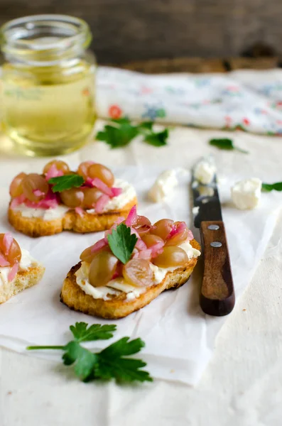 Little crusts with feta cheese and grape — Stock Photo, Image