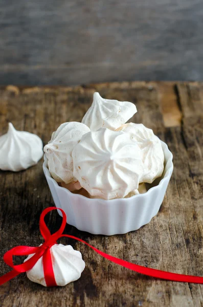Meringue in white plate on a wooden table — Stock Photo, Image