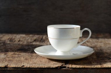 ahşap bir masa üzerinde beyaz fincan