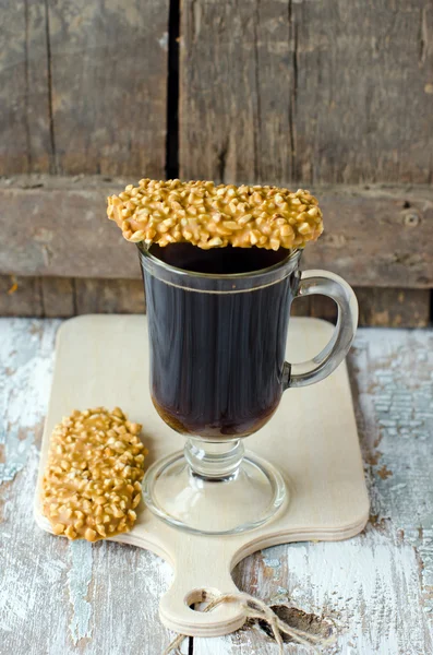 Una taza de café con una pastelería en chocolate con nueces —  Fotos de Stock