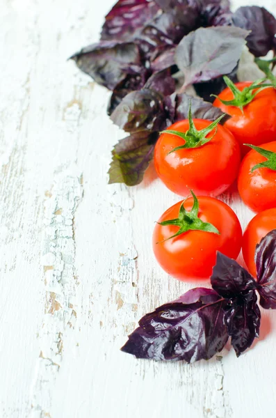 Verse tomaten en basilicum op de houten achtergrond — Stockfoto