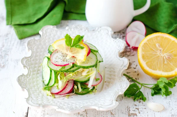 Fresh salad from cucumbers, radish and cabbage with lemon — Stock Photo, Image