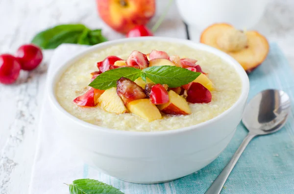 Milk porridge with peaches and cherries — Stock Photo, Image