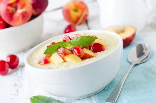 Milk porridge with peaches and cherries — Stock Photo, Image