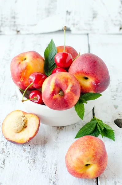 Fresh peaches and cherries in a bowl — Stock Photo, Image