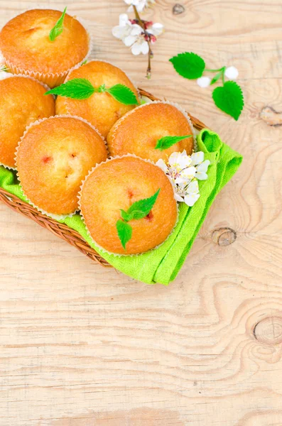 Muffins with jam on a wooden table with flowers — Stock Photo, Image