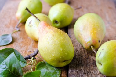 Tahta bir masada taze armutlar.