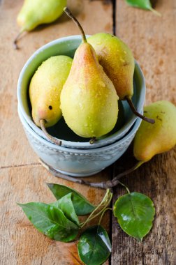 Tahta bir masada taze armutlar.