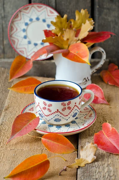 Een kopje thee op de tabel met herfst bladeren — Stockfoto