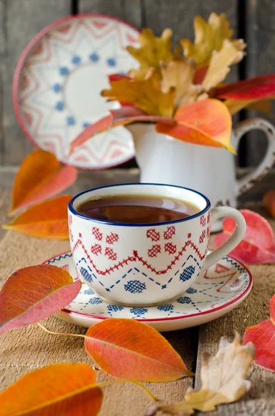 Een kopje thee op de tabel met herfst bladeren — Stockfoto