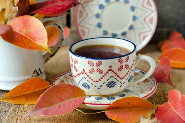 Eine Tasse Tee auf dem Tisch mit Herbstblättern — Stockfoto
