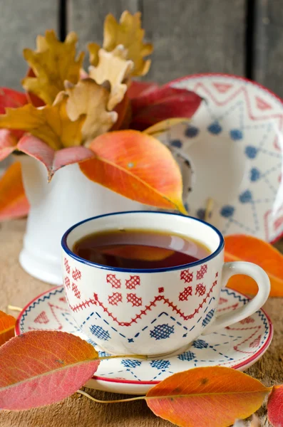 Eine Tasse Tee auf dem Tisch mit Herbstblättern — Stockfoto