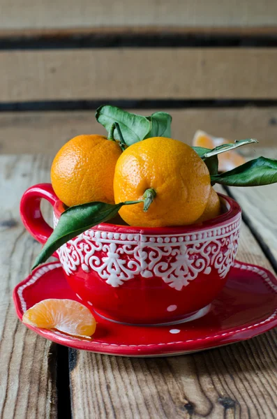 Mandarinen in roter Tasse auf Holztisch, selektiver Fokus — Stockfoto