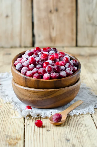 Cranberries in a wooden bowl on a wooden table — Stock Photo, Image