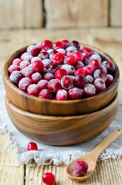 Cranberries in a wooden bowl on a wooden table — Stock Photo, Image