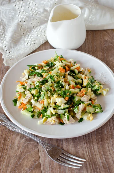 Salad with chicken, carrots, eggs and cucumbers — Stock Photo, Image